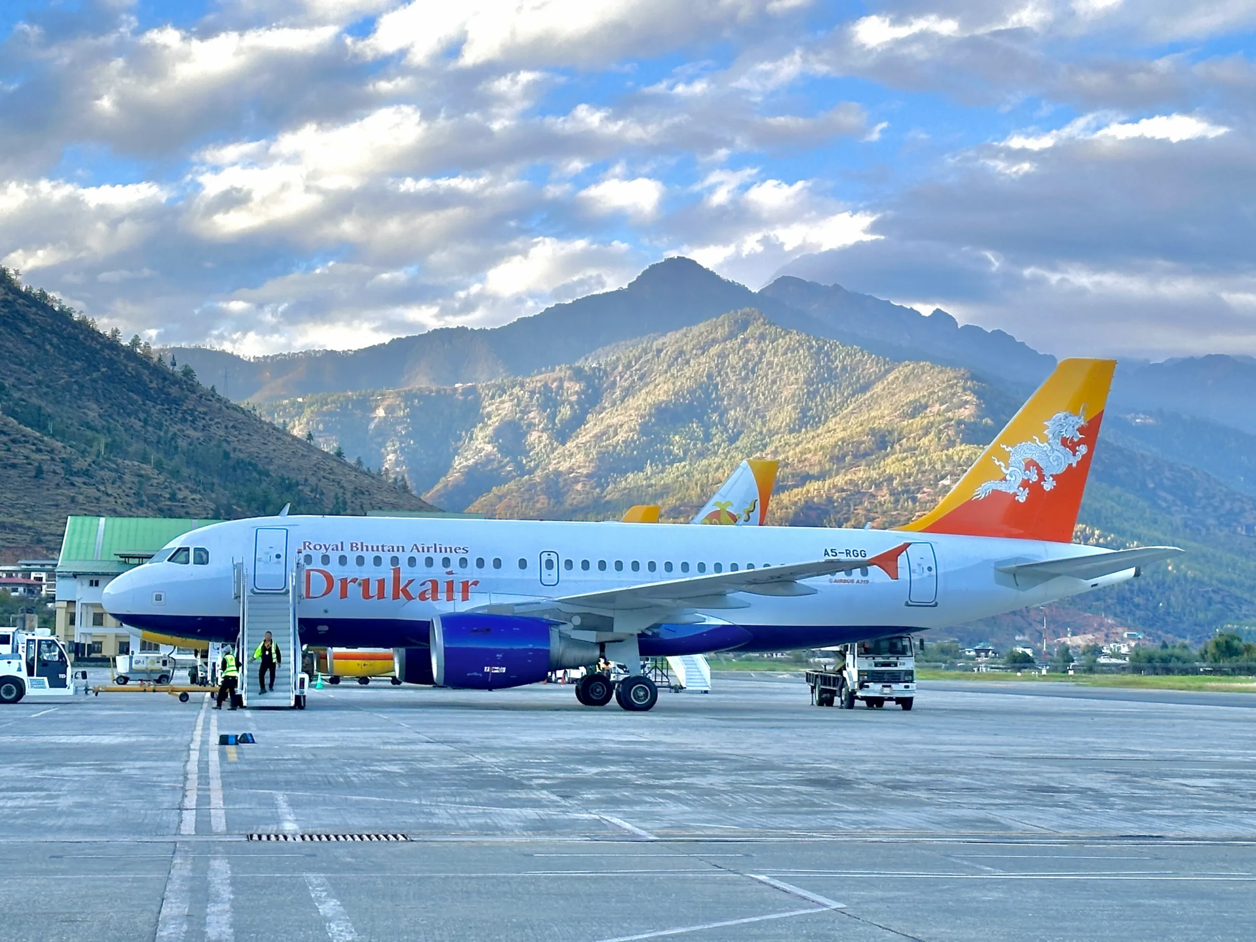 Drukair aircraft flying against the backdrop of Bhutan’s Himalayan mountains